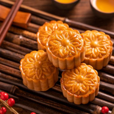 Orta Sonbahar Festivali için ahşap arka plan üzerinde bambu porsiyon uyarı tepsisi üzerinde çay bardak ile Çin geleneksel pasta Moon cake Mooncake, yakın.