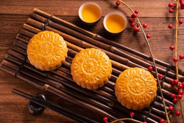 Orta Sonbahar Festivali için ahşap arka plan üzerinde bambu porsiyon uyarı tepsisi üzerinde çay bardak ile Çin geleneksel pasta Moon cake Mooncake, yakın.