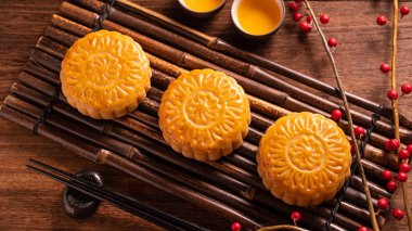Orta Sonbahar Festivali için ahşap arka plan üzerinde bambu porsiyon uyarı tepsisi üzerinde çay bardak ile Çin geleneksel pasta Moon cake Mooncake, yakın.