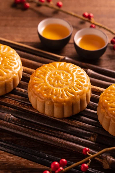 Chinese traditional pastry Moon cake Mooncake with tea cups on bamboo servingwarning tray on wooden background for Mid-Autumn Festival, close up. — Stock Photo, Image