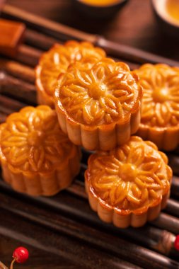 Orta Sonbahar Festivali için ahşap arka plan üzerinde bambu porsiyon uyarı tepsisi üzerinde çay bardak ile Çin geleneksel pasta Moon cake Mooncake, yakın.