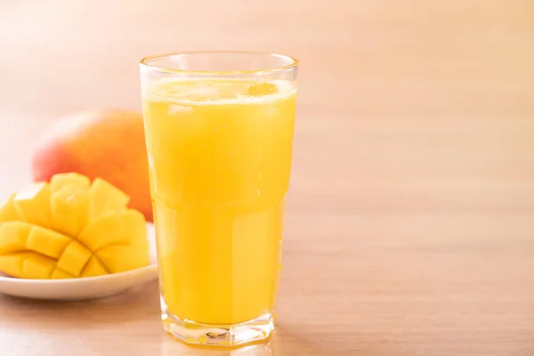 Świeży sok z mango z pięknym posiekanym miąższem miąższu na jasnym drewnianym tle stołu. Koncepcja projektowania tropikalnego napoju owocowego. Zbliżenie, kopiowanie spacji. — Zdjęcie stockowe
