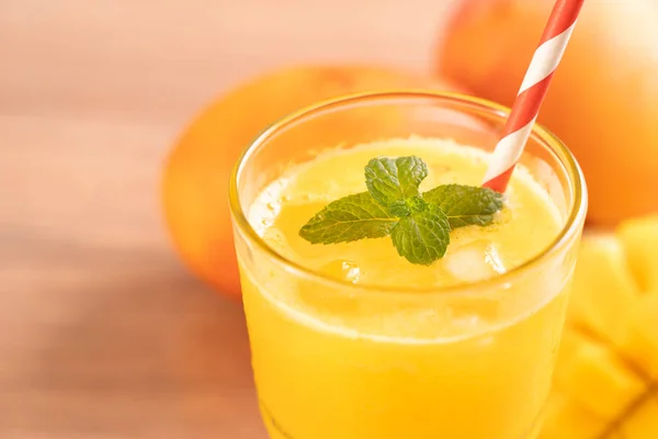 Fresh mango juice with beautiful chopped pulp flesh on bright wooden table background. Tropical fruit drink design concept. Close up, copy space. — Stock Photo, Image