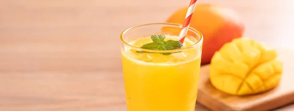 Fresh mango juice with beautiful chopped pulp flesh on bright wooden table background. Tropical fruit drink design concept. Close up, copy space. — Stock Photo, Image