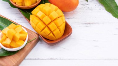 Bir tepsi ve parlak rustik ahşap arka planda taze doğranmış mango. Tropikal yaz meyve tasarım kavramı, yakın çekim, makro, kopya alanı.