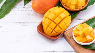 Bir tepsi ve parlak rustik ahşap arka planda taze doğranmış mango. Tropikal yaz meyve tasarım kavramı, yakın çekim, makro, kopya alanı.