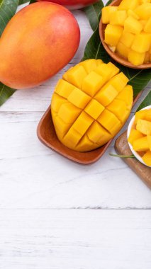 Bir tepsi ve parlak rustik ahşap arka planda taze doğranmış mango. Tropikal yaz meyve tasarım kavramı, yakın çekim, makro, kopya alanı.