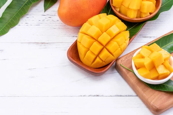 Färsk hackad Mango på en bricka och ljusa rustika trä bakgrund. Tropiska sommaren frukt designkoncept, närbild, makro, kopiera utrymme. — Stockfoto