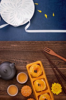 Yaratıcı Ay kek Mooncake tasarım ilham, ahşap masa konsepti pasta ve çay ile Sonbahar ortası festivalinde ay keyfini, üst görünüm, düz yatıyordu