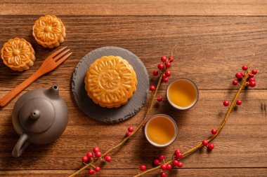 Orta Sonbahar Festivali için ahşap arka plan üzerinde tepsi servis tepsisi üzerinde çay bardağı ile Çin geleneksel pasta Moon kek Mooncake, üst görünüm, düz yatıyordu.