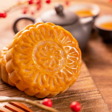 Chinese traditional pastry Moon cake Mooncake with tea cups on bamboo serving tray on wooden background for Mid-Autumn Festival, close up. clipart