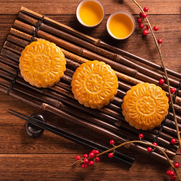 Orta Sonbahar Festivali için ahşap arka plan üzerinde tepsi servis tepsisi üzerinde çay bardağı ile Çin geleneksel pasta Moon kek Mooncake, üst görünüm, düz yatıyordu. — Stok fotoğraf