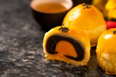Sonbahar ortası festivali için koyu arkaplanda yumurta sarısı pastası. Çin yemeği konsepti, yakın plan, boşluğu kopyala.