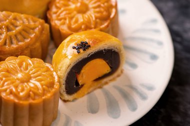 Sonbahar ortası festivali için koyu arkaplanda yumurta sarısı pastası. Çin yemeği konsepti, yakın plan, boşluğu kopyala.
