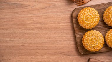 Yuvarlak şekilli taze pişmiş ay pasta pasta - Ahşap arka plan ve hizmet tepsisi, üst görünüm, düz yatıyordu Orta Sonbahar Ay Festivali için Çin moonckae.