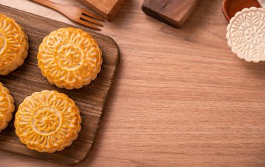 Yuvarlak şekilli taze pişmiş ay pasta pasta - Ahşap arka plan ve hizmet tepsisi, üst görünüm, düz yatıyordu Orta Sonbahar Ay Festivali için Çin moonckae.