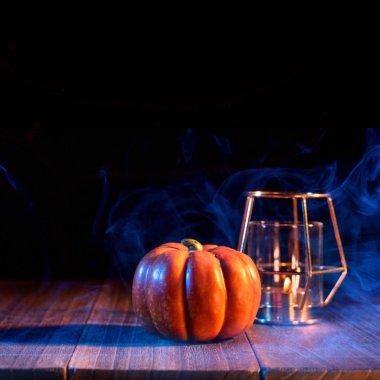 Halloween kavramı - Arka plan, hile veya tedavi etrafında çift renkli duman ile koyu ahşap bir masa üzerinde Turuncu kabak fener, yakın.