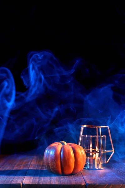 Απόκριες ιδέα-πορτοκαλί φανάρι κολοκύθα σε ένα σκούρο ξύλινο τραπέζι με διπλό χρώμα καπνού γύρω από το φόντο, τέχνασμα ή κέρασμα, κοντινό. — Φωτογραφία Αρχείου