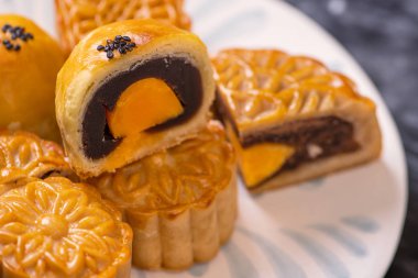 Sonbahar ortası festivali için koyu arkaplanda yumurta sarısı pastası. Çin yemeği konsepti, yakın plan, boşluğu kopyala.