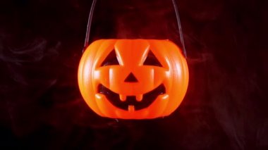 Halloween kavramı - koyu siyah arka plan, korku ve korku ruh hali, yakın izole etrafında beyaz duman ile plastik kabak fener hareketli.