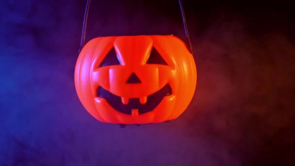 ハロウィーンのコンセプト 暗い黒の背景 怖いとホラー気分に隔離された周りの青とオレンジ色の煙で閉じるプラスチックカボチャランタン クローズアップ — ストック動画