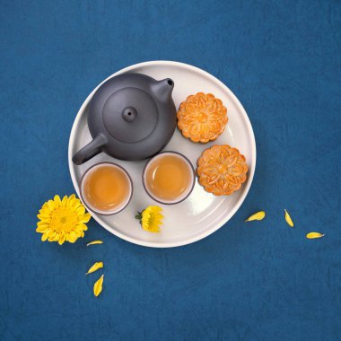 Sonbahar ortası festivali için mavi zemin üzerinde asgari sadelik düzeni ay pastaları, yaratıcı gıda tasarım konsepti, üst görünüm, düzlük, kopyalama alanı.