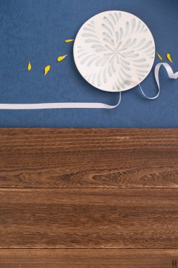 Kavramsal Sonbahar Festivali masa arkası, Ay 'ın simgesi, bulutlar ve yıldızlar plaka, kurdele ve sarı yaprakla gökyüzünde. Üst manzara, düz uzanma.