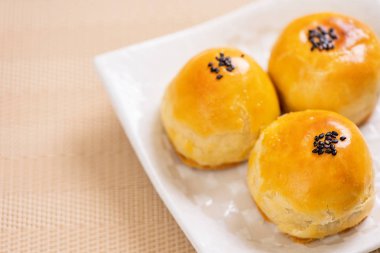 Parlak ahşap arka planda Sonbahar Festivali için yumurta sarısı pastası. Çin yemeği konsepti, yakın plan, boşluğu kopyala.