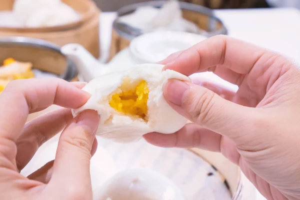 Delicious dim sum, famous cantonese food in asia, fresh and hot salted creamy custard buns in bamboo steamer in hong kong yumcha restaurant, close up