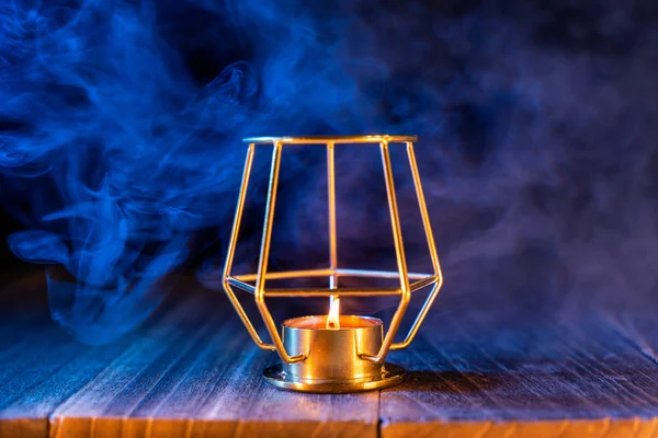 Halloween-Konzept, orangefarbene Kürbislaterne und Kerzen auf einem dunklen Holztisch mit blau-orangefarbenem Rauch im Hintergrund, Trick oder Leckerbissen, Nahaufnahme — Stockfoto