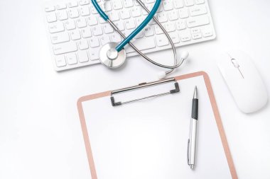 Doktor kavramı teşhis - tıbbi kayıt durumda bilgisayar klavyesi üzerinde stetoskop ve beyaz çalışma masasında kalem. Üst görünüm, düz döşeme, kopyalama alanı
