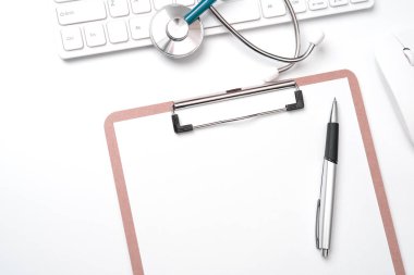Doktor kavramı teşhis - tıbbi kayıt durumda bilgisayar klavyesi üzerinde stetoskop ve beyaz çalışma masasında kalem. Üst görünüm, düz döşeme, kopyalama alanı