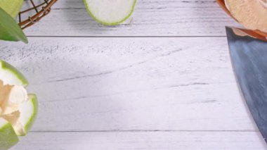 Genç asyalı kadın hazırlanıyor ve parlak beyaz ahşap masa üzerinde mutfakta bir tepsi üzerinde soyulmuş taze pomelo hizmet, üst görünüm, havai görünüm, yaşam tarzı.