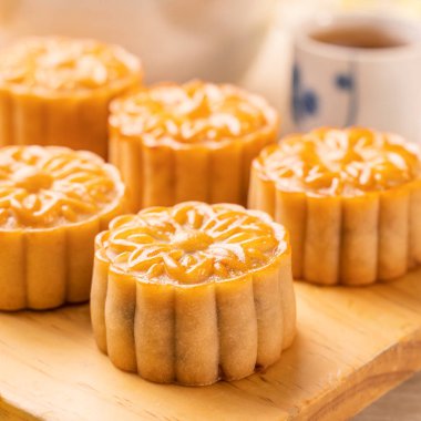 Parlak ahşap masa üzerinde çay ile Ay kek ve deneyin hizmet, Orta Sonbahar festivali geleneksel gıda düzeni tasarım tatil konsepti, yakın çekim, kopya alanı.