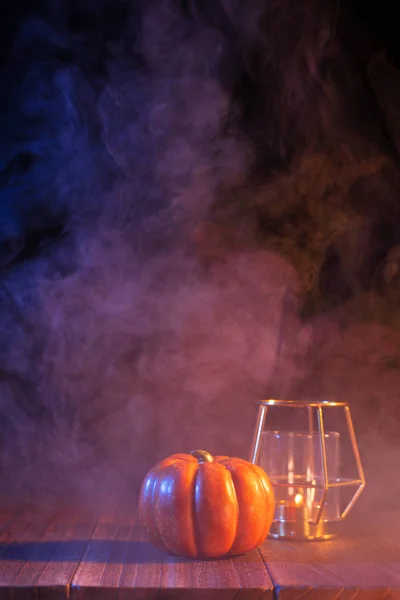 Halloween-Konzept, gruselige Dekoration mit brennender Kerze und Kerzenständer mit blauem Rauch auf dunklem Holztisch, Nahaufnahme. — Stockfoto