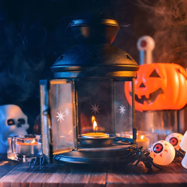 Halloween-Konzept, gruselige Dekoration mit brennender Kerze und Kerzenständer mit blauem Rauch auf dunklem Holztisch, Nahaufnahme. — Stockfoto