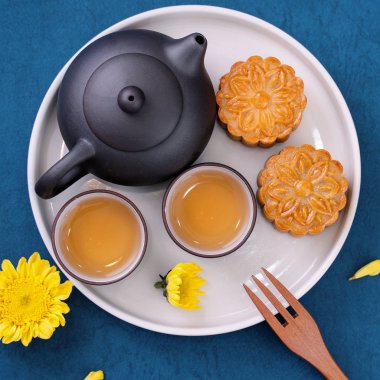 Sonbahar ortası festivali için mavi zemin üzerinde asgari sadelik düzeni ay pastaları, yaratıcı gıda tasarım konsepti, üst görünüm, düzlük, kopyalama alanı.