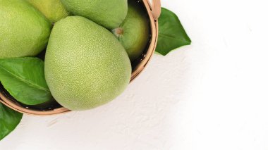 Taze pomelo, parlak beyaz arka plan üzerinde yeşil yaprak ile bambu sepeti greyfurt. Sonbahar Ortası Festivali için mevsim meyveleri. Üst te. Düz yatıyordu.