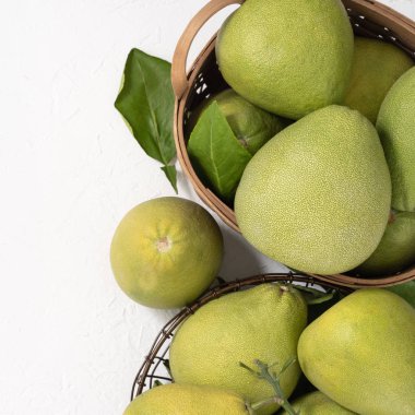 Taze pomelo, parlak beyaz arka plan üzerinde yeşil yaprak ile bambu sepeti greyfurt. Sonbahar Ortası Festivali için mevsim meyveleri. Üst te. Düz yatıyordu.