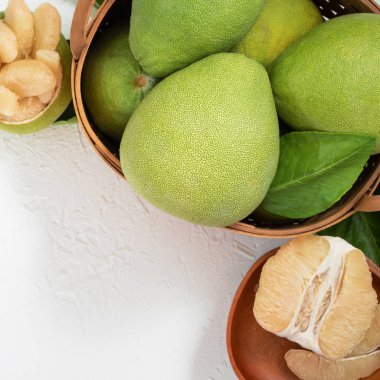 Taze pomelo, parlak beyaz arka plan üzerinde yeşil yaprak ile bambu sepeti greyfurt. Sonbahar Ortası Festivali için mevsim meyveleri. Üst te. Düz yatıyordu.