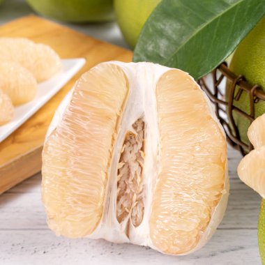 Taze soyulmuş pomelo, greyfurt, parlak ahşap masa arka plan üzerinde gölgedock. Sonbahar Ortası Festivali için mevsim meyveleri, yakın çekim, kopyalama alanı.
