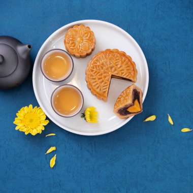 Sonbahar ortası festivali için mavi zemin üzerinde asgari sadelik düzeni ay pastaları, yaratıcı gıda tasarım konsepti, üst görünüm, düzlük, kopyalama alanı.