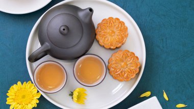 Sonbahar ortası festivali için mavi zemin üzerinde asgari sadelik düzeni ay pastaları, yaratıcı gıda tasarım konsepti, üst görünüm, düzlük, kopyalama alanı.