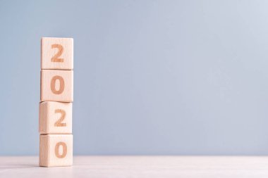 Soyut 2020 tasarım konsepti - ahşap masa ve düşük doygunluk gri mavi arka plan üzerinde geometrik ahşap bloklar küpler, yakın, kopyalama alanı.