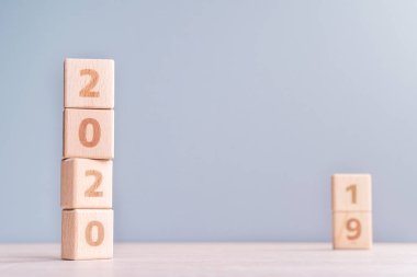 Soyut 2020 & 2019 Yeni yıl geri sayım tasarım konsepti - ahşap bloklar ahşap masa ve düşük doygunluk mavi arka plan küpler, yakın çekim, kopyalama alanı.