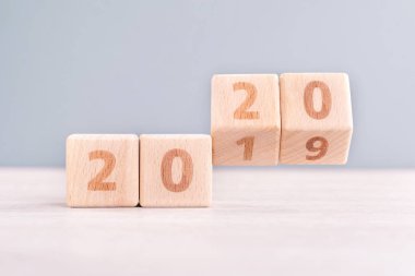 Soyut 2020 & 2019 Yeni yıl geri sayım tasarım konsepti - ahşap bloklar ahşap masa ve düşük doygunluk mavi arka plan küpler, yakın çekim, kopyalama alanı.