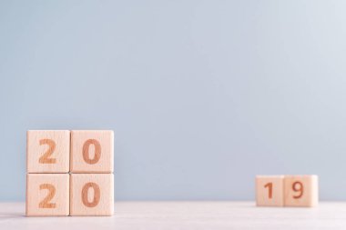 Soyut 2020 & 2019 Yeni yıl geri sayım tasarım konsepti - ahşap bloklar ahşap masa ve düşük doygunluk mavi arka plan küpler, yakın çekim, kopyalama alanı.