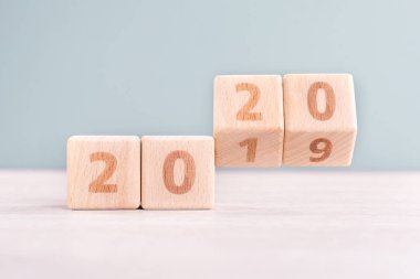 Soyut 2020 & 2019 Yeni yıl geri sayım tasarım konsepti - ahşap bloklar ahşap masa ve düşük doygunluk yeşil arka plan küpler, yakın çekim, kopyalama alanı.