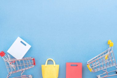 Soyut tasarım unsuru, yıllık satış konsepti, alışveriş sezonu - pastel mavi arka planda izole edilmiş küçük sarı sepet, üst manzara, düz yatış.