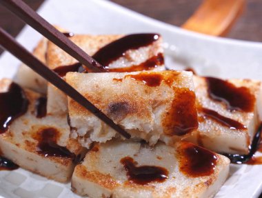 Lezzetli şalgam kekinin üzerine kara soya sosu dök restoranda geleneksel Çin turplu keki, kapat, uzayı kopyala.